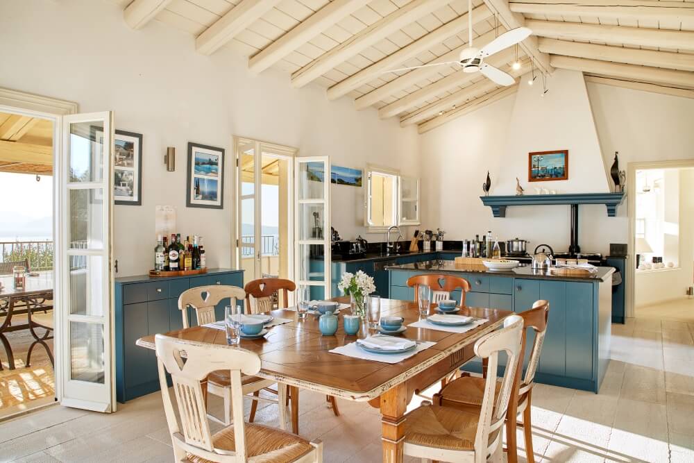 Open-plan dining and kitchen area at Villa Eremia with vaulted wooden ceiling
