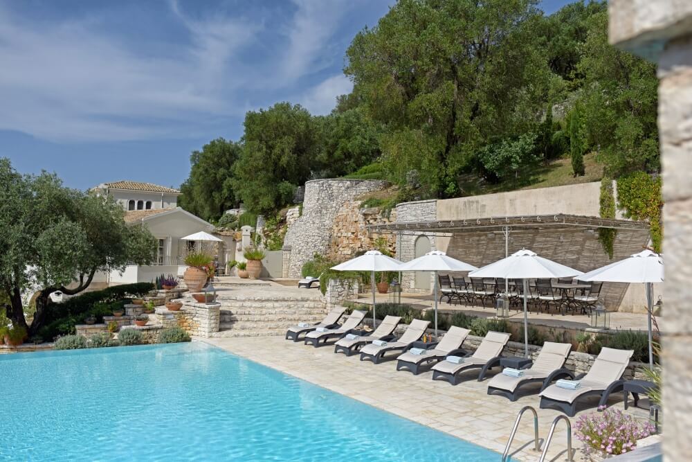 Sunbathing terrace with loungers beside the infinity pool at Villa Eremia, Corfu