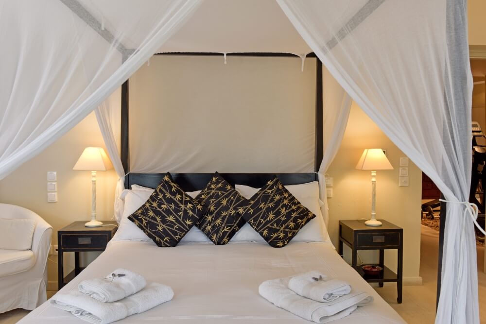 Master bedroom at Villa Eremia featuring an emperor four-poster bed and elegant linens
