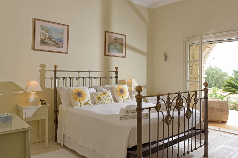 Twin bedroom at Villa Eremia with classic wrought-iron bed frames and bright airy décor