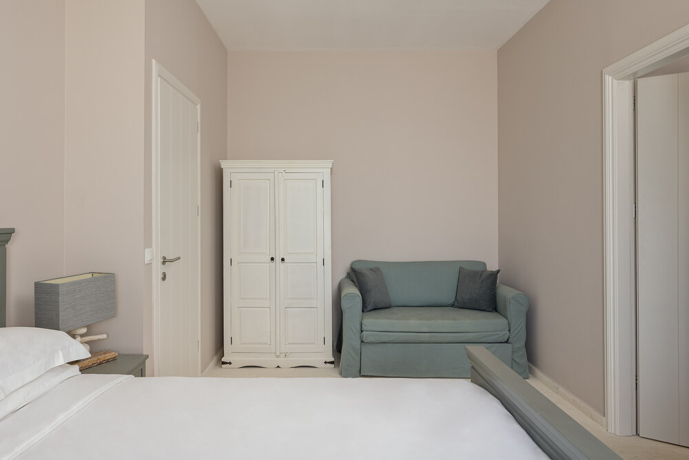 Entrance area at Elyonas Cottage with reading armchair beside the door, Eremia Estate Corfu
