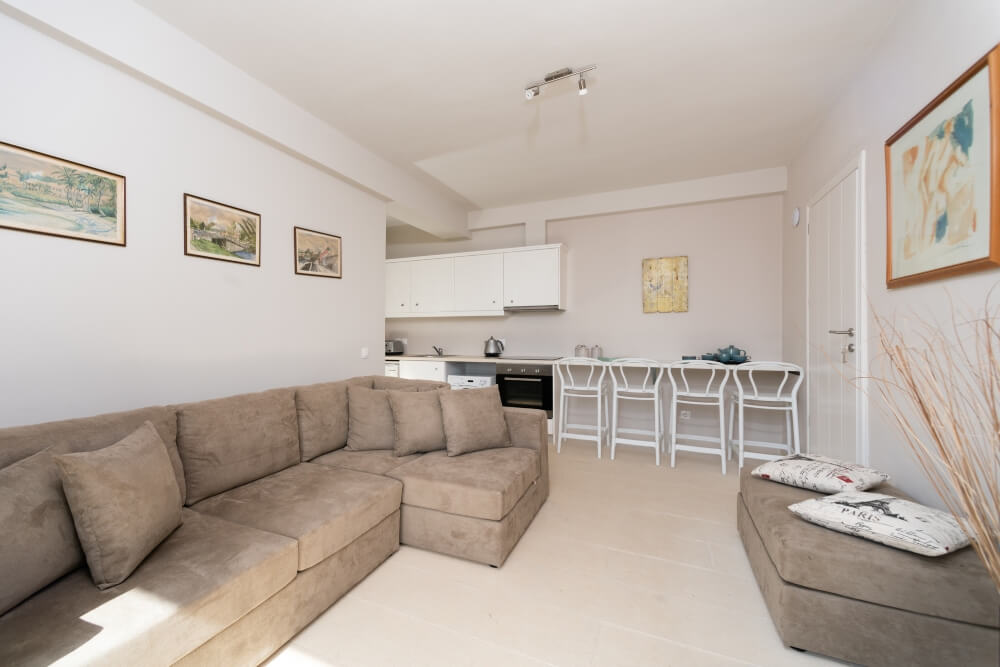 Open-plan living and kitchen area at Elyonas Cottage with corner sofa and breakfast bar
